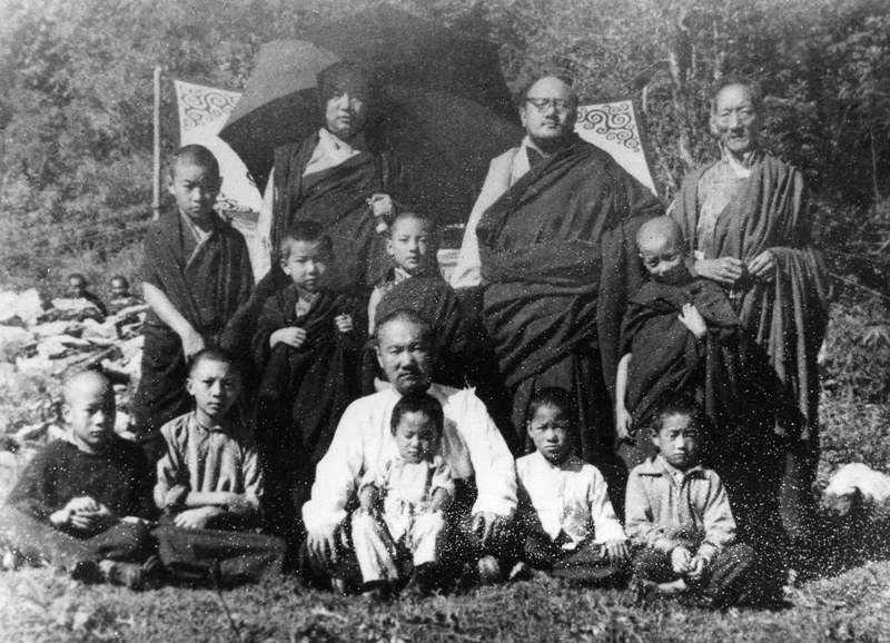 En haut, de gauche à droite : le XVIe Karmapa, Dzogchen Pönlop Rinpoché, Kalu Rinpoché. Au milieu, de gauche à droite : Tendzin Chöny, Kongtrul Rinpoché, Shamar Rinpoché, Gyalsé Tülku. En bas, de gauche à droite : Tsültrim Namgyal, Jigmé Rinpoché, Gyalkar Gönam, Tashi Namgyal, Khenpo Chödrak, Gyurmé Tsültrim. Photographie prise le premier jour de la cérémonie d'inauguration des travaux à Rumtek, au début des années 60